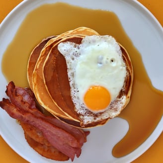 American Pancakes with bacon, egg, and syrup.