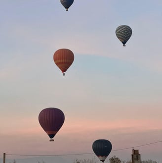 Colorful hot air balloons flying over the desert landscapes near Marrakech at sunrise