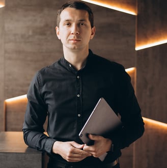 a man in a black shirt and a laptop