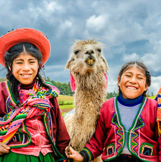 two happy kids from the Andes with a llama. Dos ninos felices de los Andes con una llama