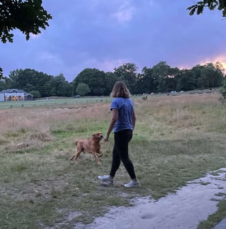 a woman walking a dog on a path