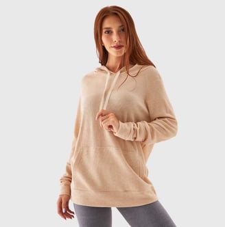 a woman in a beige hoodie and leggings