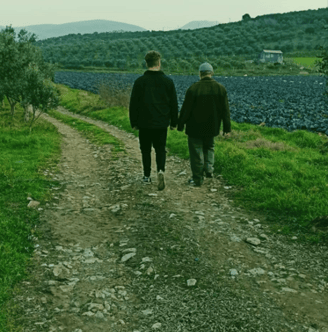 İzmir ormanlarında yürüyüş yapan iki kişi, birlikte başarı ve ilerlemeyi temsil eder