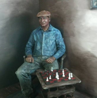 a statue of a man sitting in a chair