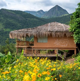 Mud house stay in Kerala with mountains in background.