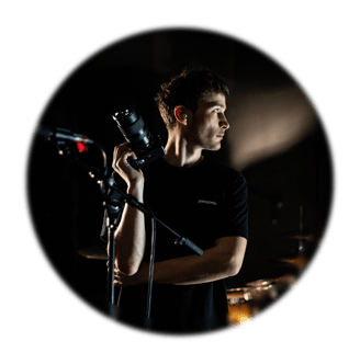 Portrait d’un photographe en concert, appareil en main, capturé en lumière de scène