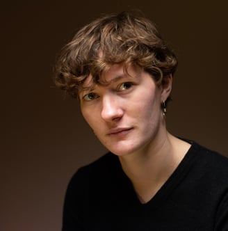 Personne aux cheveux courts et à l'air sérieux sur un fond marron