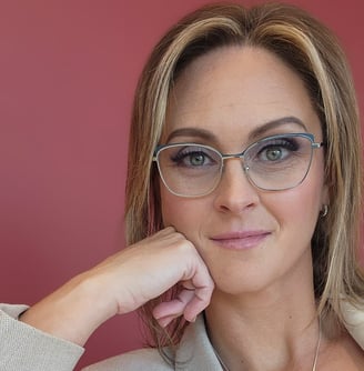 a woman in a white top and glasses