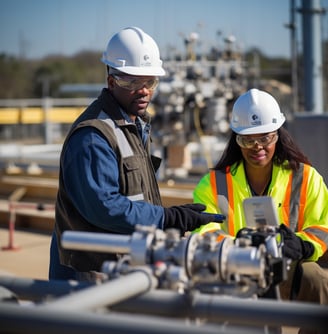 NexOp in safety gear standing in front of a large pipe
