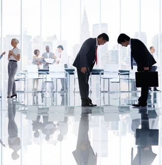 a group of business people standing in a conference room