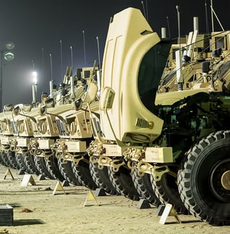 a group of soldiers are standing in front of a line of military vehicles