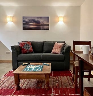 a sofa table and chair in a room with a colourful rug