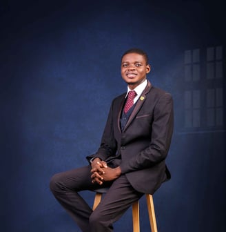 a man in a suit and tie is sitting on a stool