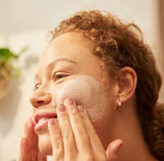 women washing her face using a gentle cleanser