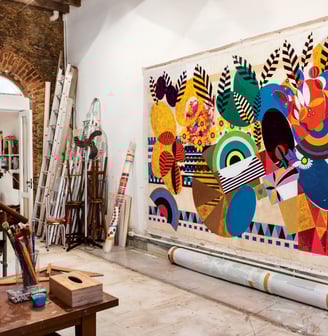 Ateliê luminoso de Beatriz Milhazes com suas obras coloridas e detalhadas em processo.