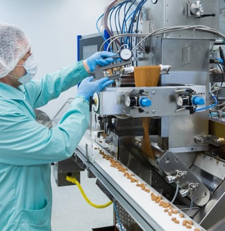 a person in a lab coat and gloves working on a machine