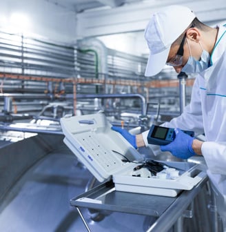 a man in a white lab coat and gloves is holding a laptop computer