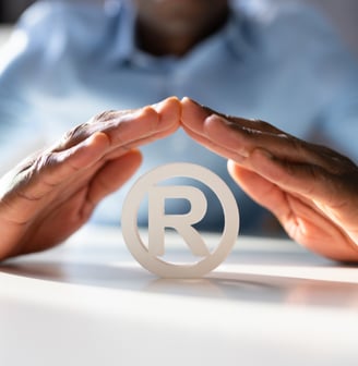 a person holding a paper cutout of a symbol of a registered trademark trademark trademark
