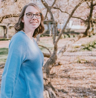 a woman in glasses and a blue sweater