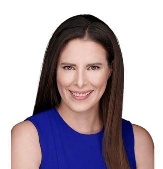 a pretty woman with brown hair and brown eyes in a blue dress smiling at the camera.