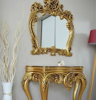 A luxury gold console table with gold mirror 
