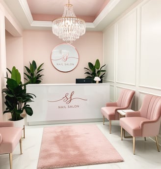 a salon with pink chairs and a chandelier