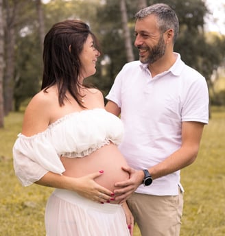 Sessió de fotos d'embaràs d'una parella amb dona embarassada en entorn natural exterior
