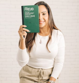 Fátima com um livro de Freud em frente a metade do rosto