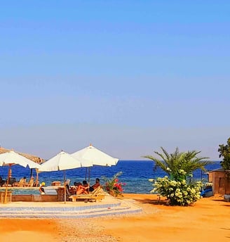 uma praia com guarda-sóis ao redor de uma piscina no Egito