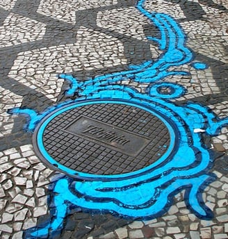 Grafite do artista Zezão, uma intervenção usando a tampa do bueiro