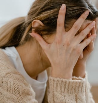 a woman with her hands on her face