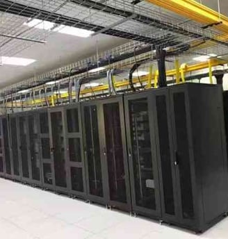 a large machien room with yellow fiber cable trays and wire mesh cable trays