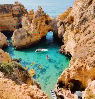 a boat in the water near a cliff