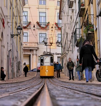 a trolley car on a narrow street in a city