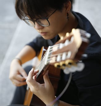 a woman with glasses and a guitar in her hands