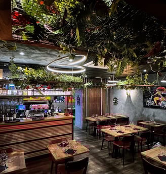 a restaurant with a large amount of plants and a bar