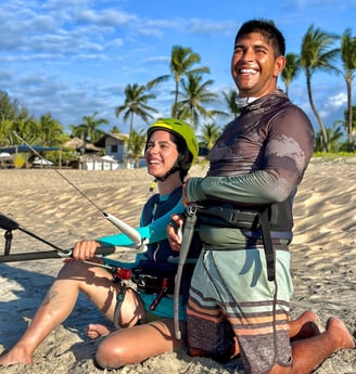 mulher jovem fazendo aula de kitesurf ao lado do instrutor.