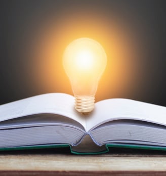a book open book with a light bulb on top of it