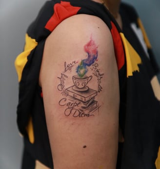 Watercolor coffee cup design with books tattoo at Dudo's Tattoos Hyderabad
