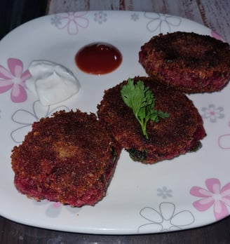 a plate with three sweet potato and beetroot  cutlets and sauce