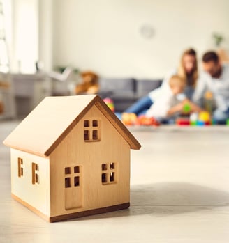 a wooden house with a family in the background