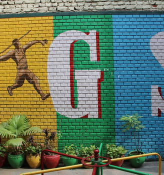 a colorful painted brick wall with a sign that says gogg