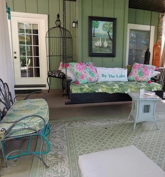 a covered terrace with a daybed and chairs
