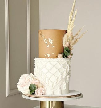 a cake with a gold and white cake topper