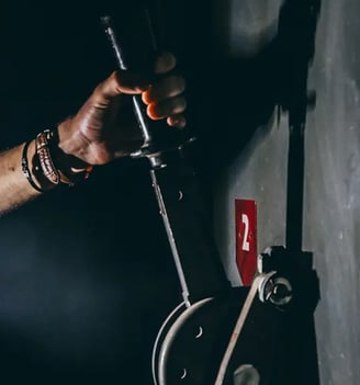 un homme tire un levier pour résoudre une étape de l'escape game