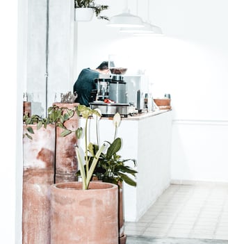 a man in a green shirt and a potted plant