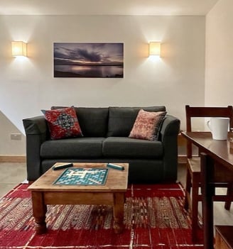 a sofa table and chair in a room with a colourful rug