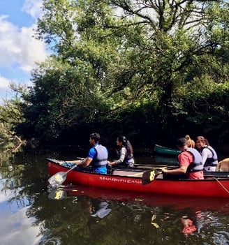 a group of people in a canoe on a river