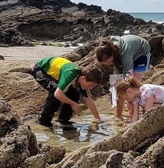 a woman and two children playing in the water