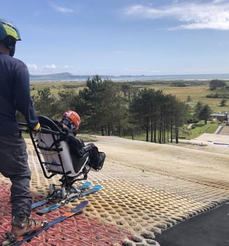 a man in a helmet and skis on a dry ski slope